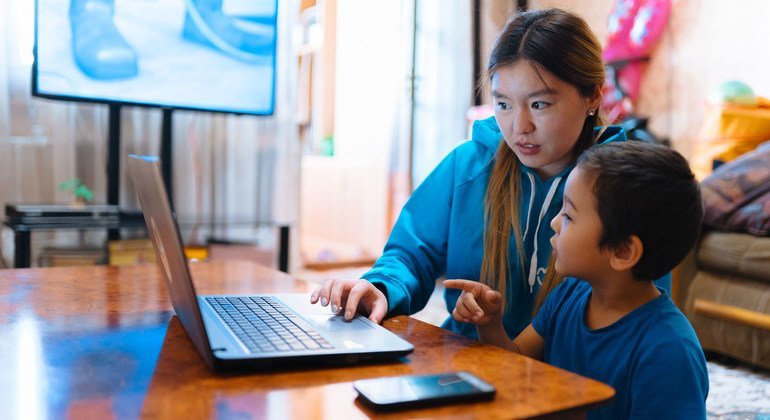 A UNICEF volunteer transcribes lessons at home in Osh, Kyrgyzstan with her nephew  as part of a UNICEF response to the COVID-19 pandemic.