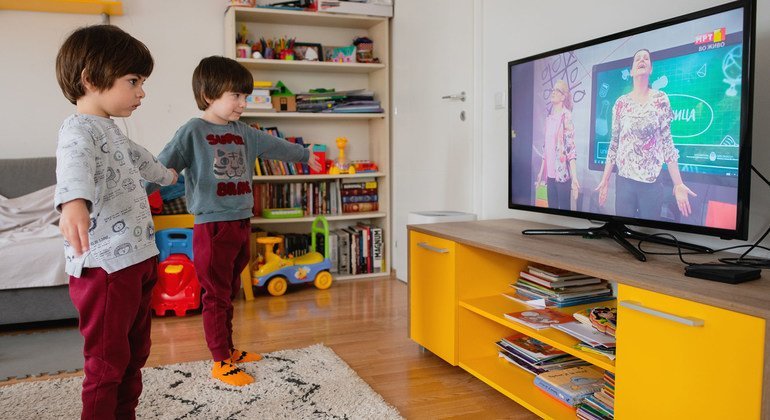 Twin brothers in North Macedonia practice yoga for children as they follow a TV-classroom programme broadcast on national television.