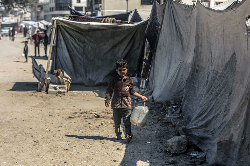 Un niño busca agua en la ciudad de Gaza.