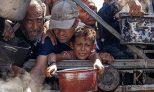 La población de Gaza espera alimentos en un centro de ayuda humanitaria.