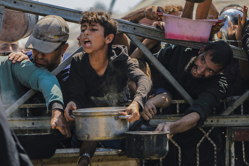 Des Gazaouis réclament de la nourriture à un point de distribution.