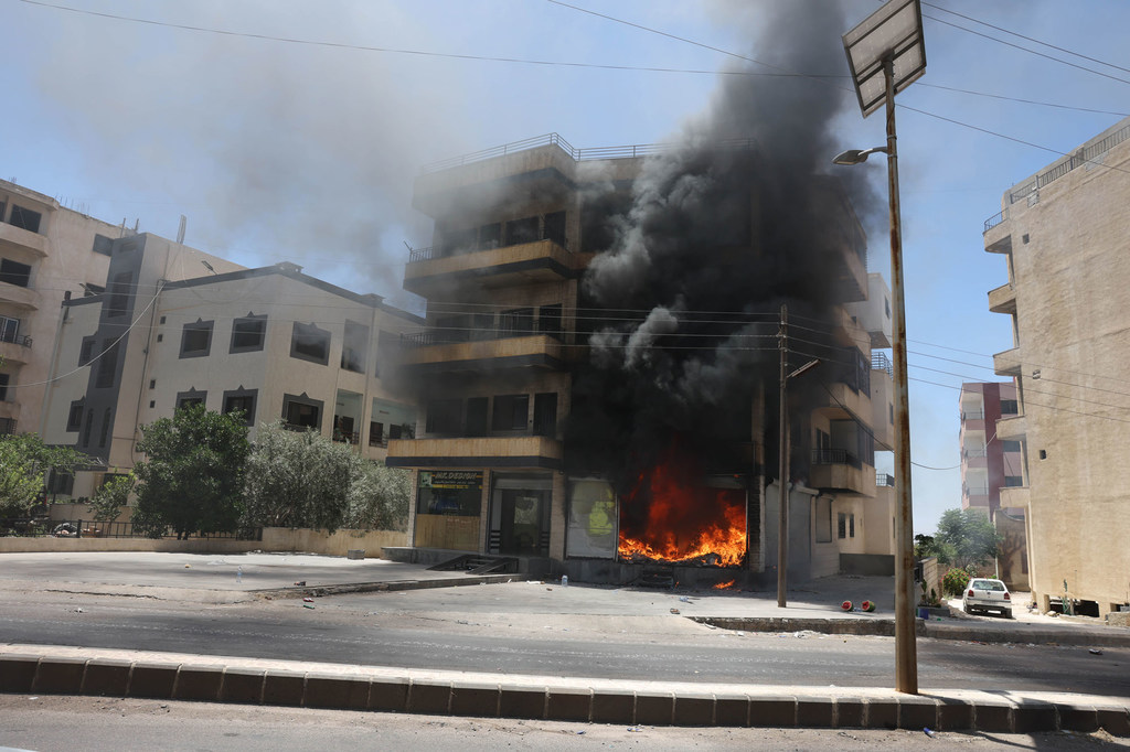 Un edificio arde en la ciudad de Suweida, en el oeste de Siria.
