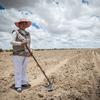 A woman in Bolivia prepares her land for growing crops.