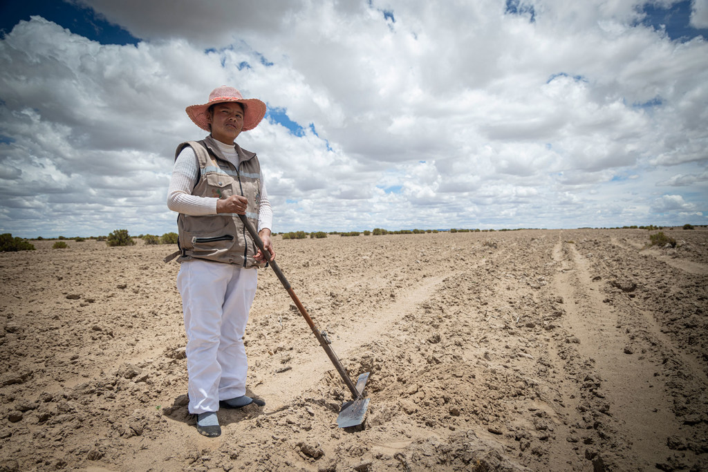 Una mujer en Bolivia prepara su tierra para cultivar.