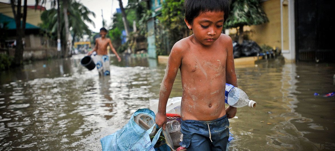 Menino caminha por bairro afetado por tufão nas Filipinas. 