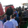 在意大利兰佩杜萨，移民在地中海被渔船救起后下船。