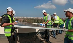 Workers install solar panels in Beirut, Lebanon.