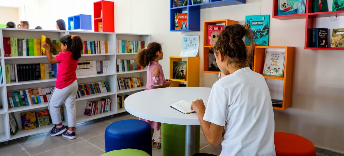 Children of different ages spend time in the settlement's library.