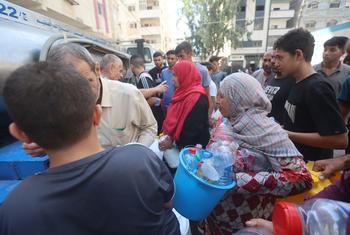 Des Palestiniens font la queue pour obtenir de l'eau à Gaza.