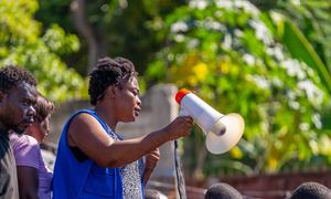 IOM staff member, Rose, supports displaced people as they pick up humanitarian supplies.