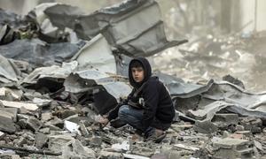 A boy sits amongst the destruction of the Al-Touam neighbourhood in the northern Gaza Strip.