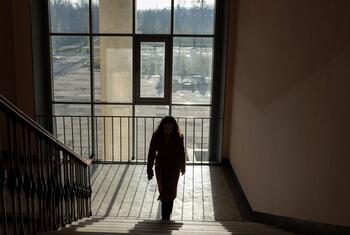 Veronika, uma estudante ucraniana de 16 anos, sobe uma escada dentro do Liceu Zlatopil na região de Kharkiv, no leste da Ucrânia, iluminada pela luz do dia. Ela continua sua educação apesar das hostilidades em andamento durante o quarto ano da guerra em grande escala.