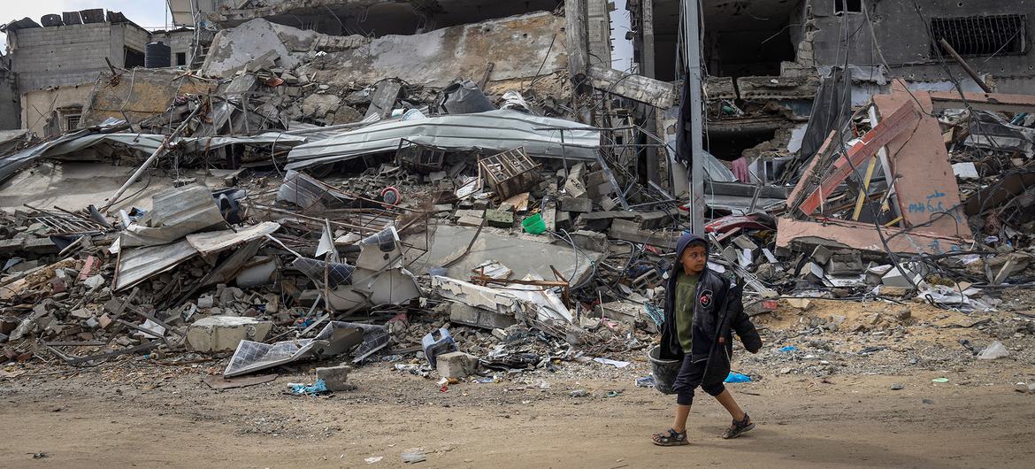 غزہ کے علاقے خان یونس میں ملبے کا ڈھیر بنی رہائشی عمارتوں کے پاس سے گزرتا ہوا ایک بچہ۔