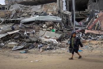 Um menino caminha pelos escombros de seu bairro em Khan Younis, no sul de Gaza