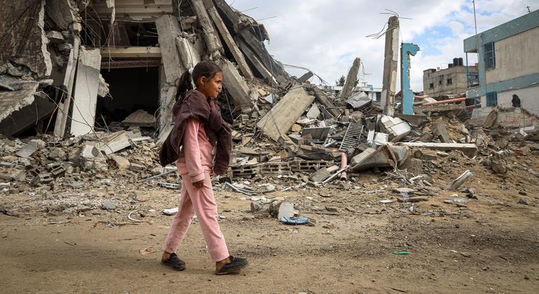 在加沙地带南部的汗尤尼斯，一名年轻女孩走过被摧毁的街道。