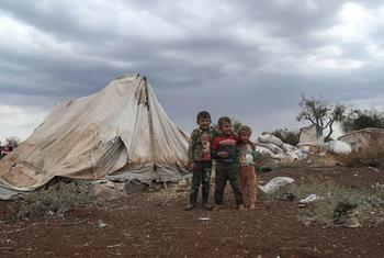 من الأرشيف: أطفال صغار نزحوا بسبب النزاع في سوريا يقفون أمام أحد الملاجئ.