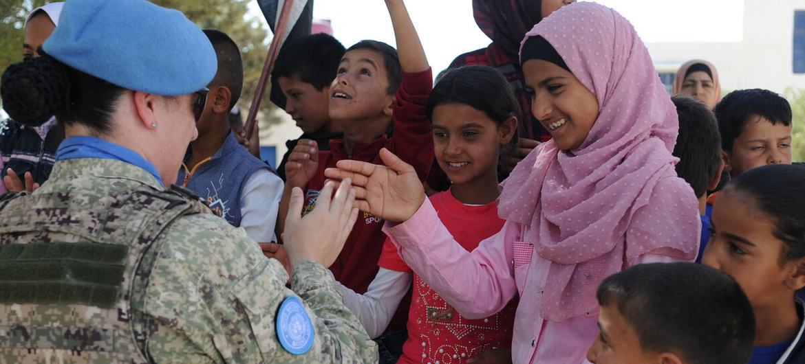 Boina azul com alunos da Escola Faouar na Síria, uma das quatro escolas reformadas pela Força de Desengajamento da ONU