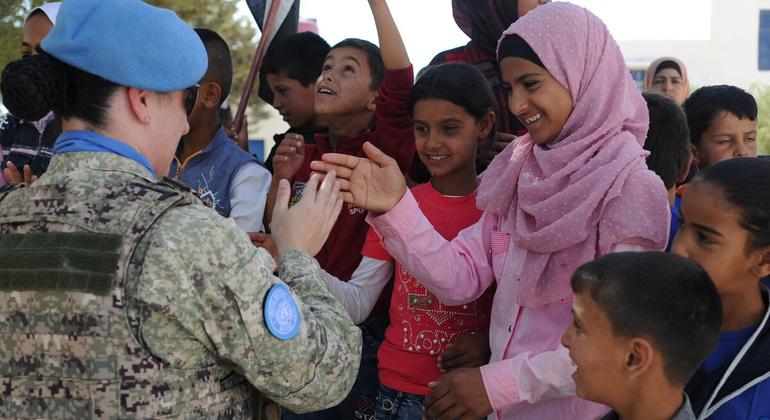 Un miembro del personal de mantenimiento de la paz saluda a los alumnos de la Escuela Faouar en Siria, que fue una de las cuatro escuelas rehabilitadas por la Fuerza de Retirada de las Naciones Unidas.