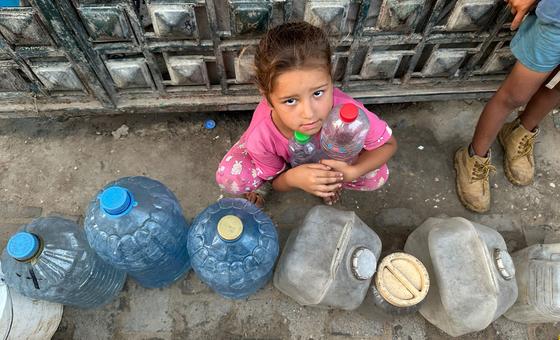 A child waits to fill water containers in Gaza.