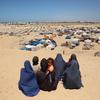 Women look across a temporary camp near the Philadelphi Corridor in Rafah, Gaza.