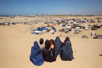 Women look across a temporary camp near the Philadelphi Corridor in Rafah, Gaza.