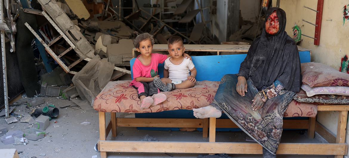 A woman and her children sit inside their destroyed home, in Burij in the central Gaza Strip. A woman and her children sit inside their destroyed home, in Burij in the central Gaza Strip.