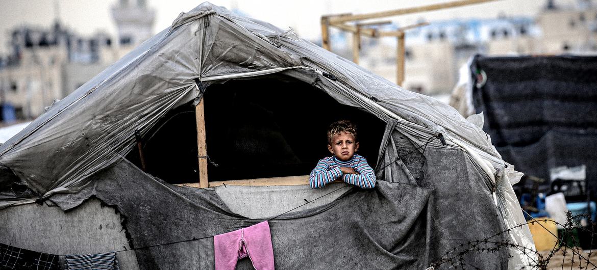 A child looks out from a makeshift shelter in Rafah, in the south of the Gaza Strip. A child looks out from a makeshift shelter in Rafah, in the south of the Gaza Strip.