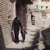 امرأة وابنها يسيران في بغداد عاصمة العراق.