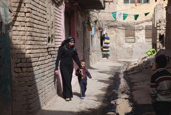 इराक़ की राजधानी बग़दाद के फ़ुटहाल इलाक़े में एक माँ अपने बच्चे के साथ.