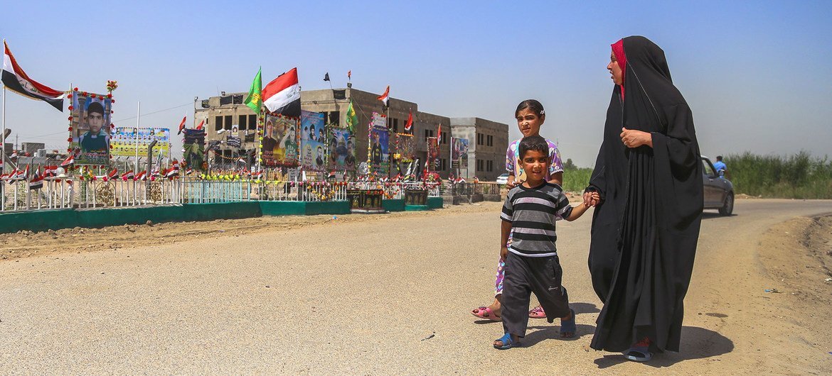 Une famille passe devant un mémorial érigé sur le lieu d'un attentat-suicide, revendiqué par Daech, au stade Al-Shuhadaa à Babil, en Iraq.