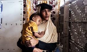 A woman holds her one-year-old son during a visit to a UNICEF nutrition facility in a Rohingya refugee camp in Cox's Bazar, Bangladesh.