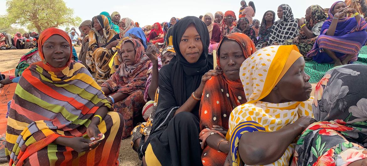 Refugiados do Sudão esperam para recolher itens de ajuda numa aldeia fronteiriça no Chade.
