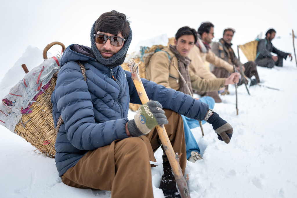 सर्दियों के कपड़ों में सजे पुरुष पाकिस्तान के स्कार्दू के पास बर्फीली चुंडा घाटी में हिमनदों को जोड़ने की तकनीक का प्रदर्शन कर रहे हैं।