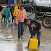 Niños colectando agua durante las primeras lluvias del invierno en Gaza.