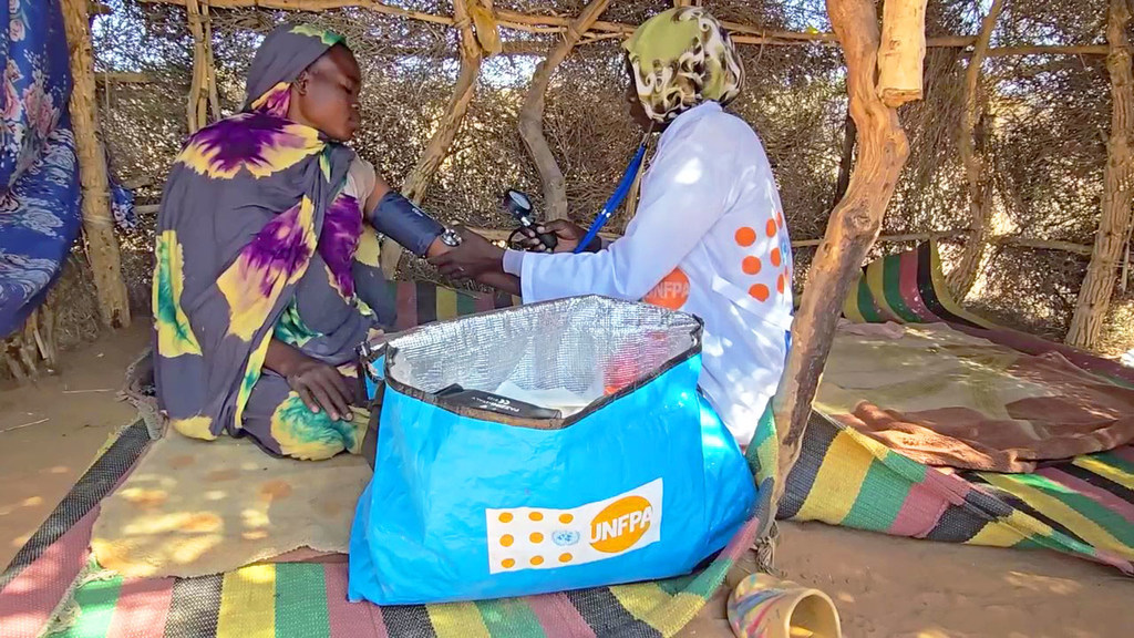 Un travailleur de santé de l'UNFPA fournit une aide médicale à une femme déplacée à Tawila, au Soudan, au milieu d'une grave crise humanitaire.