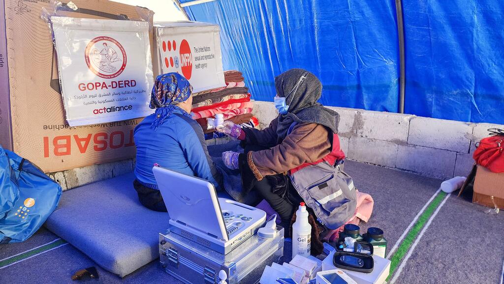 A mobile health team from UNFPA provides reproductive health services to displaced women and girls in a temporary shelter in northern Syria, offering dignity kits and psychosocial counselling.