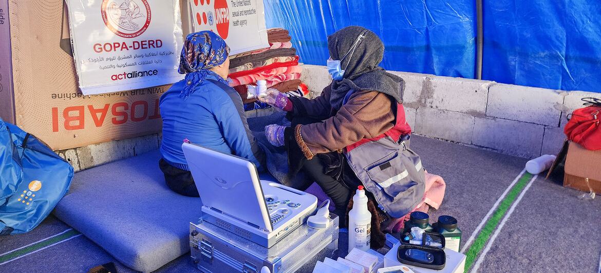 A mobile health team from UNFPA provides reproductive health services to displaced women and girls in a temporary shelter in northern Syria, offering dignity kits and psychosocial counselling.