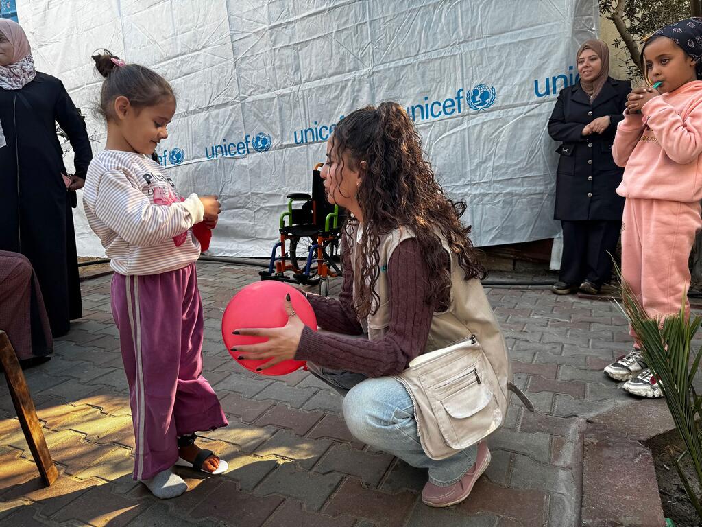 一名联合国儿童基金会工作人员在加沙地带为一名儿童提供心理健康支持。
