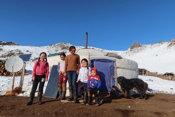 蒙古农村一个牧民家庭的孩子在蒙古包外站成一排。