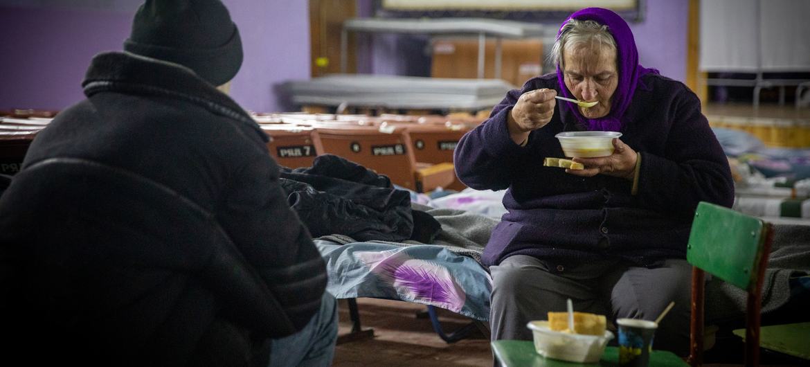 Une femme ukrainienne âgée prend un repas dans un centre de transit géré par le HCR à Pavlohrad.