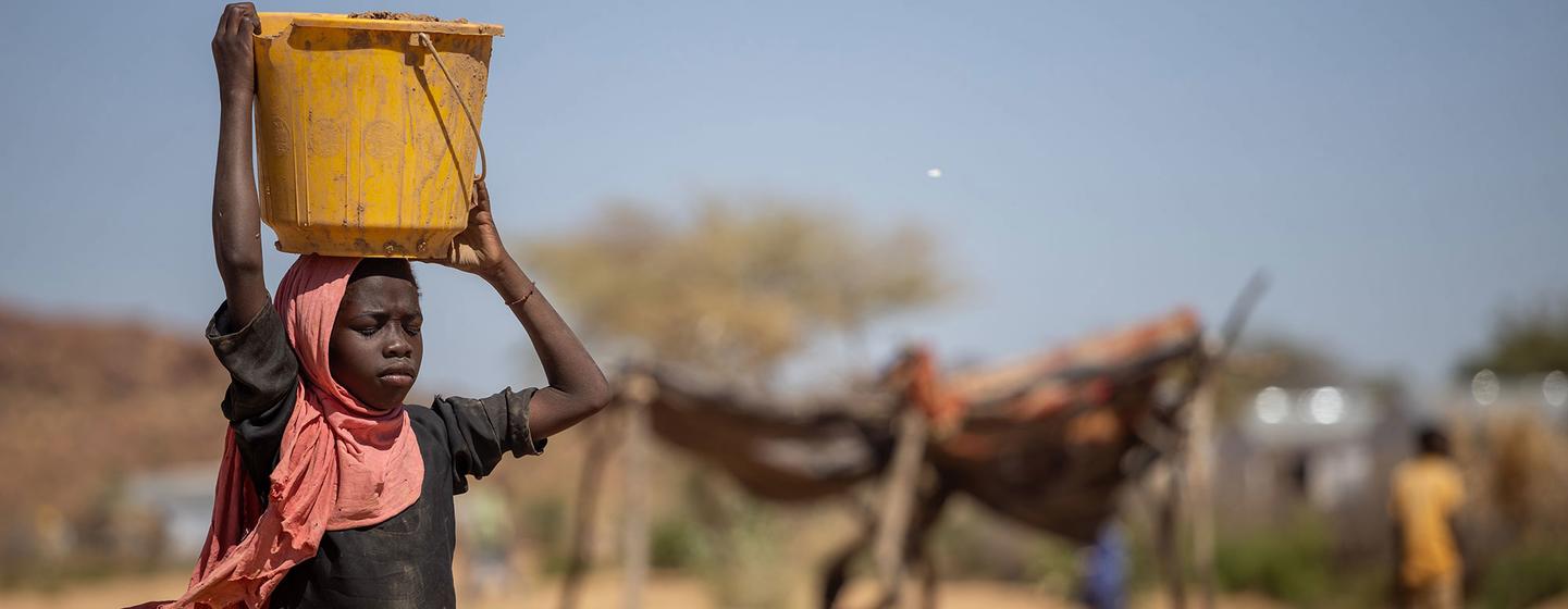 Une fille porte de l'eau dans le camp pour réfugiés soudanais de Farchana, au Tchad.