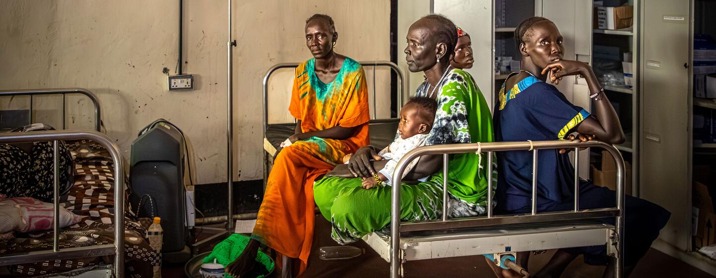 Des femmes et des enfants sont assis dans des lits d'hôpital à l'hôpital du comté d'Akobo, dans l'État de Jonglei, au Soudan du Sud, le 21 février 2026. L'hôpital, géré par le gouvernement, manque de médicaments et de ressources et traite de nombreux civils pour des blessures par balle et des brûlures.