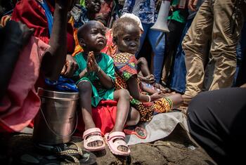 दक्षिण सूडान के जोंगलेई राज्य में दक्षिण सूडान में हिंसा से विस्थापित बच्चे, मानवीय सहायता की मांग करते हुए एक एपिस्कोपल चर्च के बाहर बैठे हैं, एक बच्चे के साथ प्रार्थना में हाथ पकड़े हुए।