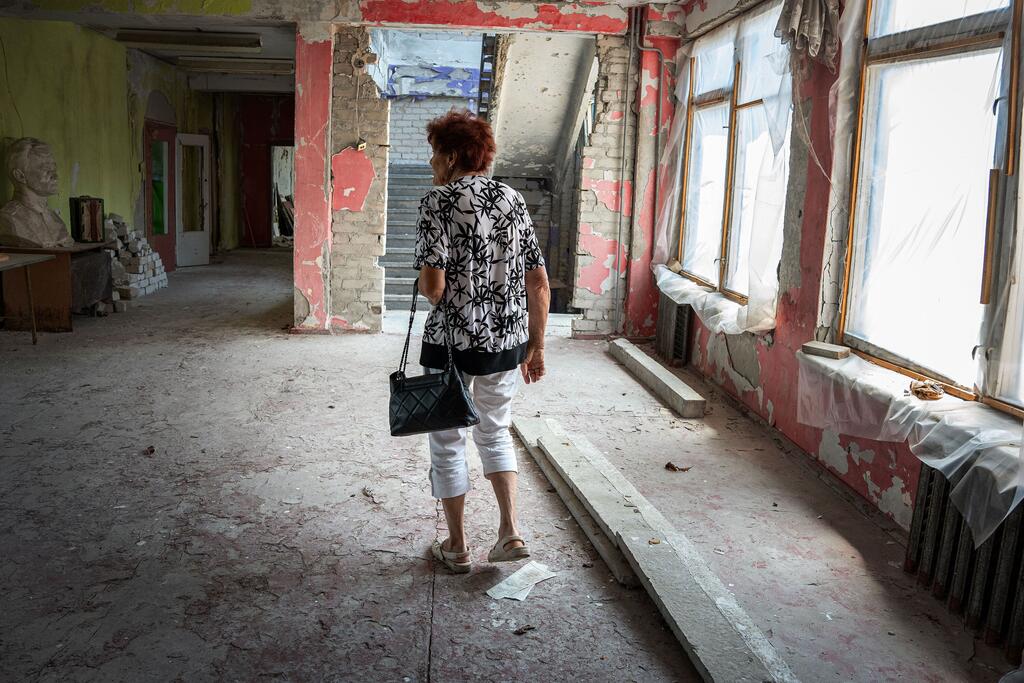 Una mujer camina por los pasillos medio destruidos y medio reparados de una escuela en la Ucrania devastada por la guerra, reflexionando sobre los tiempos más felices como maestra.