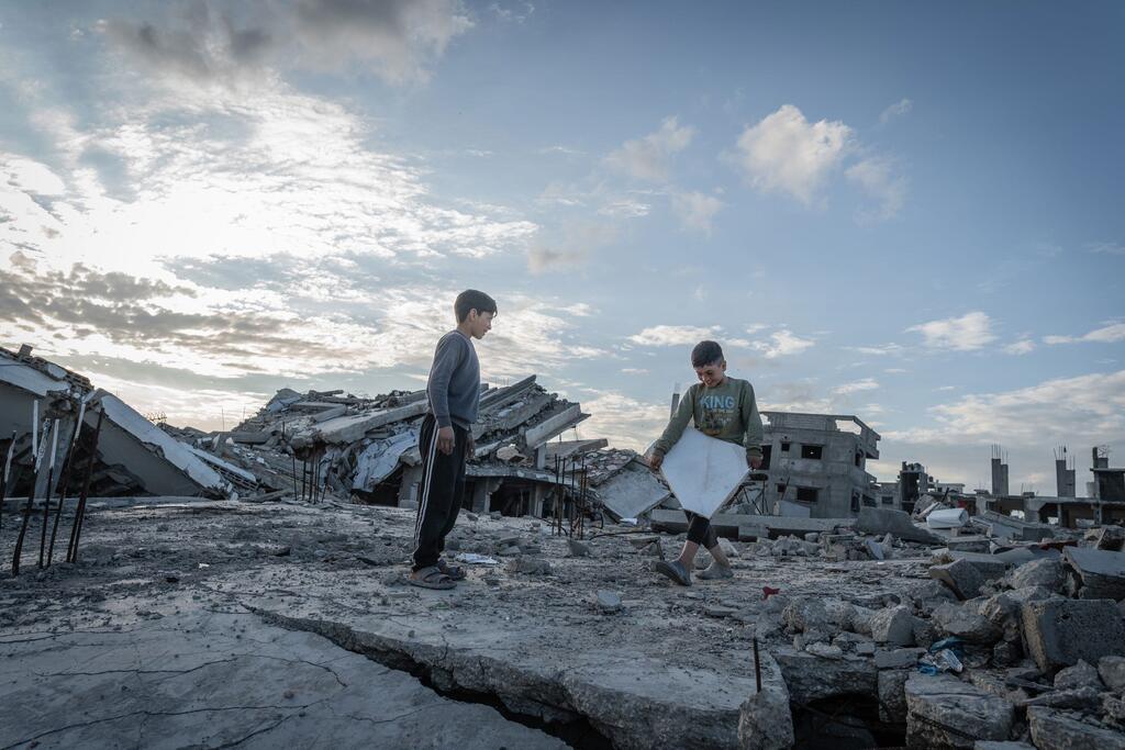 A boy moves rubble from the ruins of his family's home in Gaza.