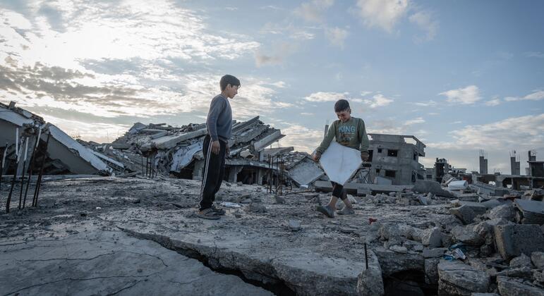 Два палестинских ребенка, Язан (10) и Али Мухаммад (7), играют на обломках своего разрушенного дома в Аль-Заркаа, город Газа, после возвращения из-за перемещения из-за войны, теперь живут в палатке и полагаются на помощь ВПП.