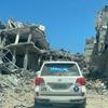 سيارة تابعة للأمم المتحدة تمر وسط أنقاض مباني في مدينة خان يونس جنوب قطاع غزة.
