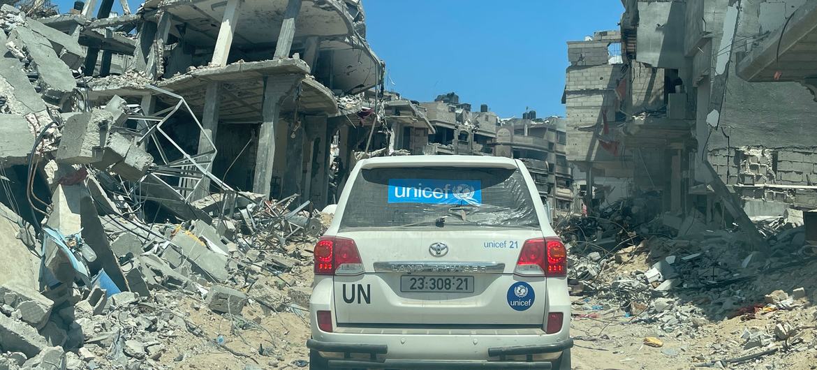 سيارة تابعة للأمم المتحدة تمر وسط أنقاض مباني في مدينة خان يونس جنوب قطاع غزة.