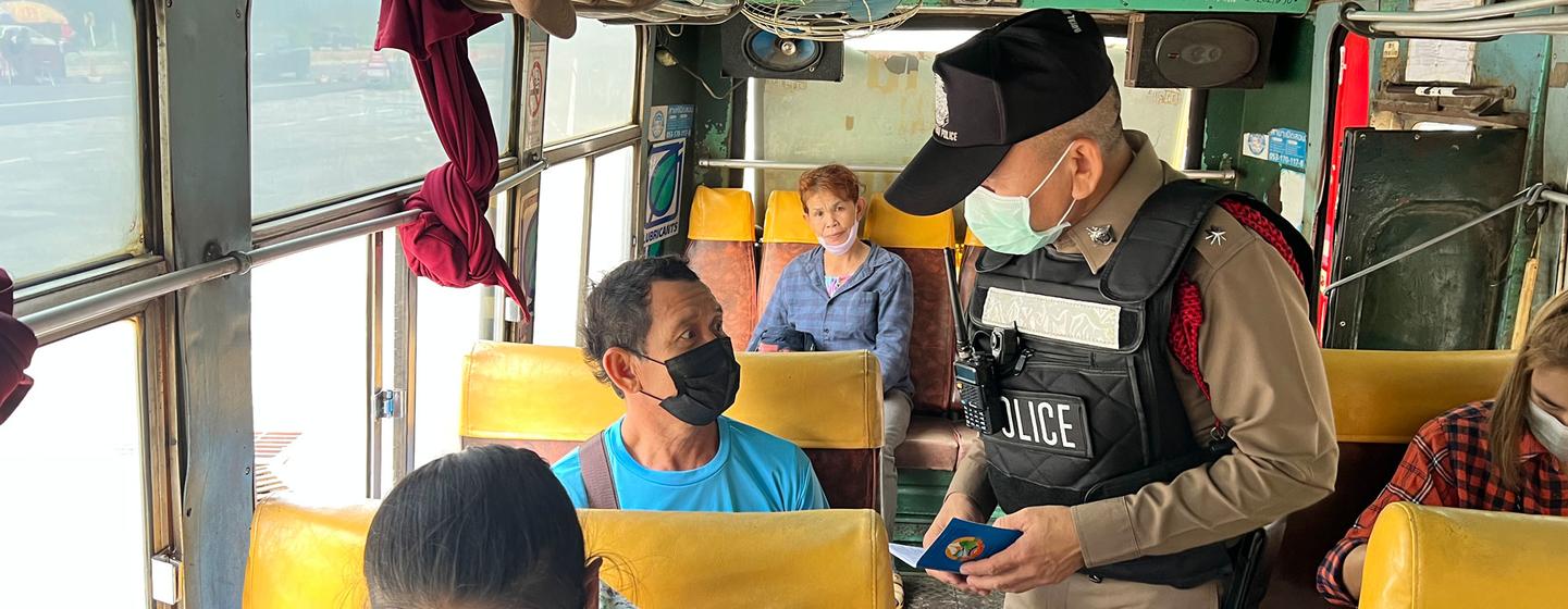 A police officer questions passengers on a bus travelling from the north of Thailand.