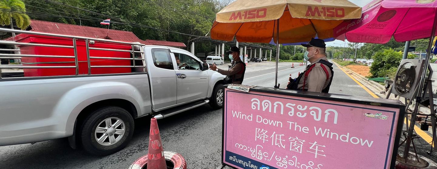 Police officers conduct a security check at a roadblock in northern Thailand.